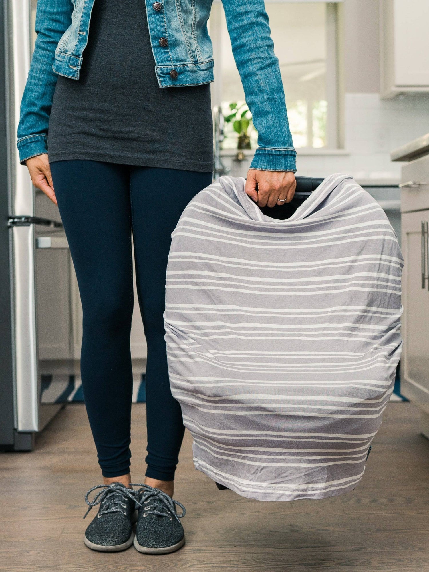 The Bebe au Lait - 5-in-1 Multi-Use Nursing Cover in Metro being used as a carseat cover