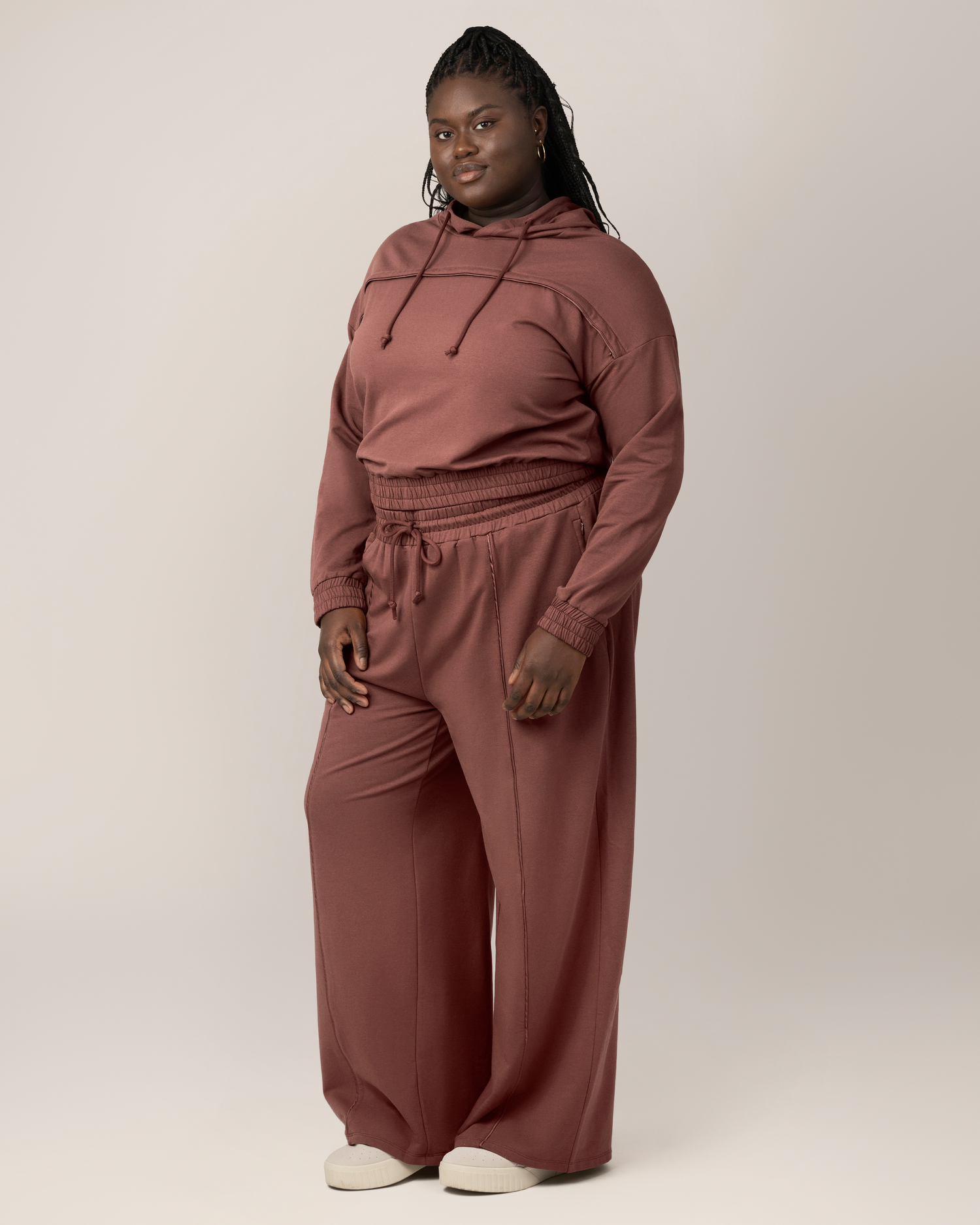 3/4 full body view of model wearing the Mila High-Waisted Wide Leg Pant in Redwood, paired with the matching Mila Cropped Nursing Hoodie in Redwood. 