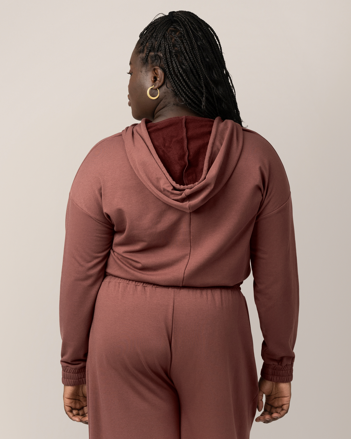 Back view of model wearing the Mila Cropped Nursing Hoodie in Redwood