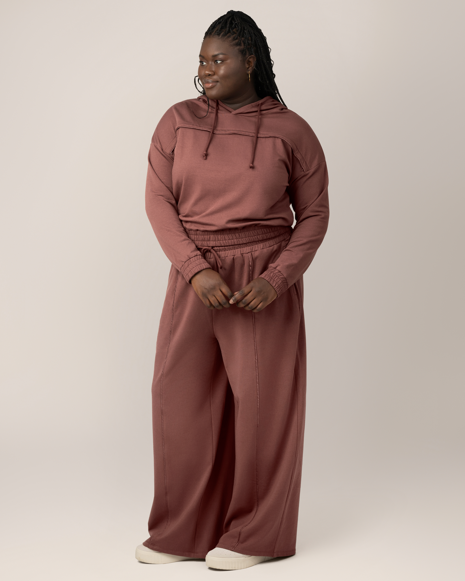 Full body view of model wearing the Mila Cropped Nursing Hoodie, paired with matching Mila High-Waisted Wide Leg Pant in Redwood. @model_info:Bintou is wearing an X-Large.