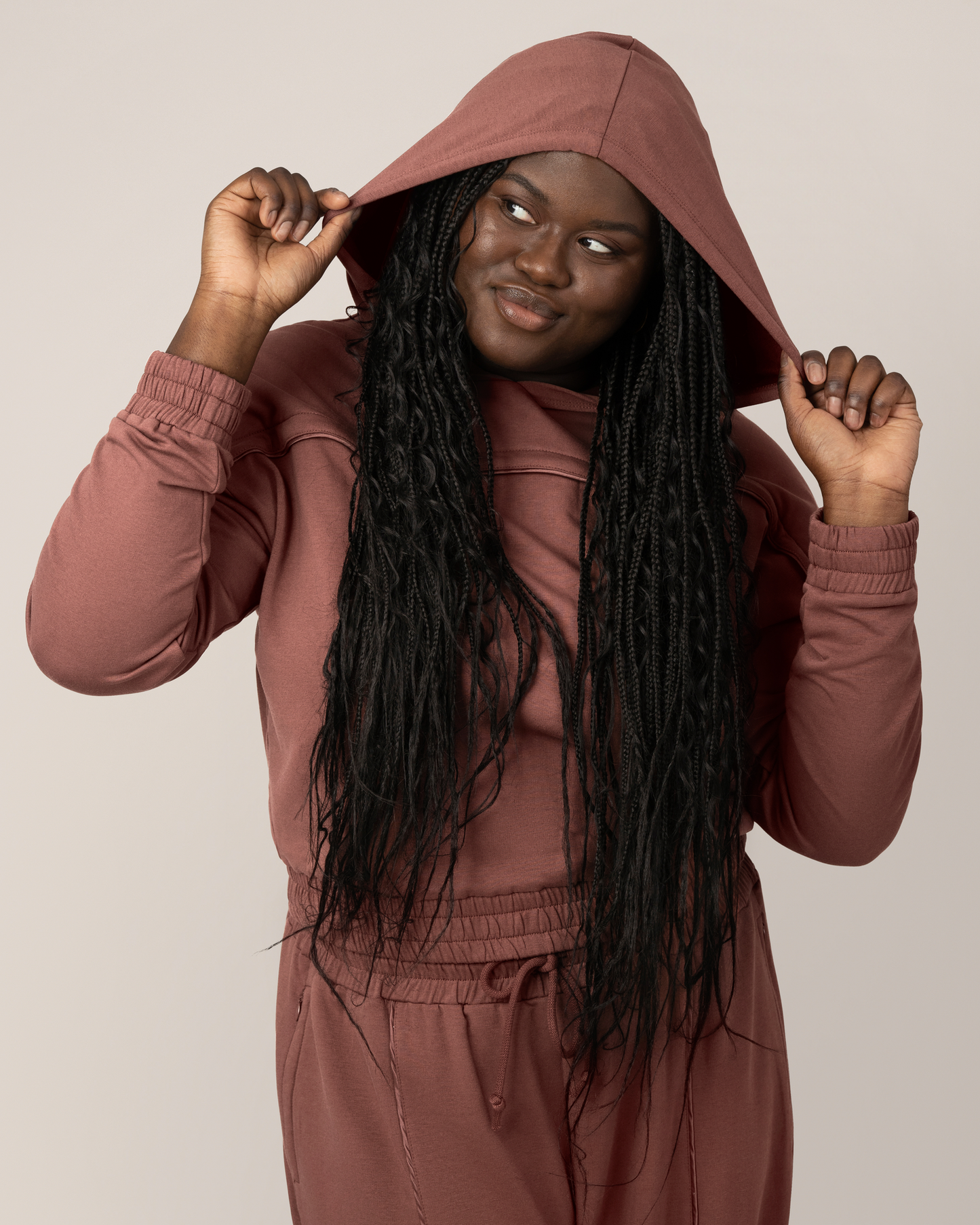 Front view of model wearing the Mila Cropped Nursing Hoodie in Redwood, with hood on