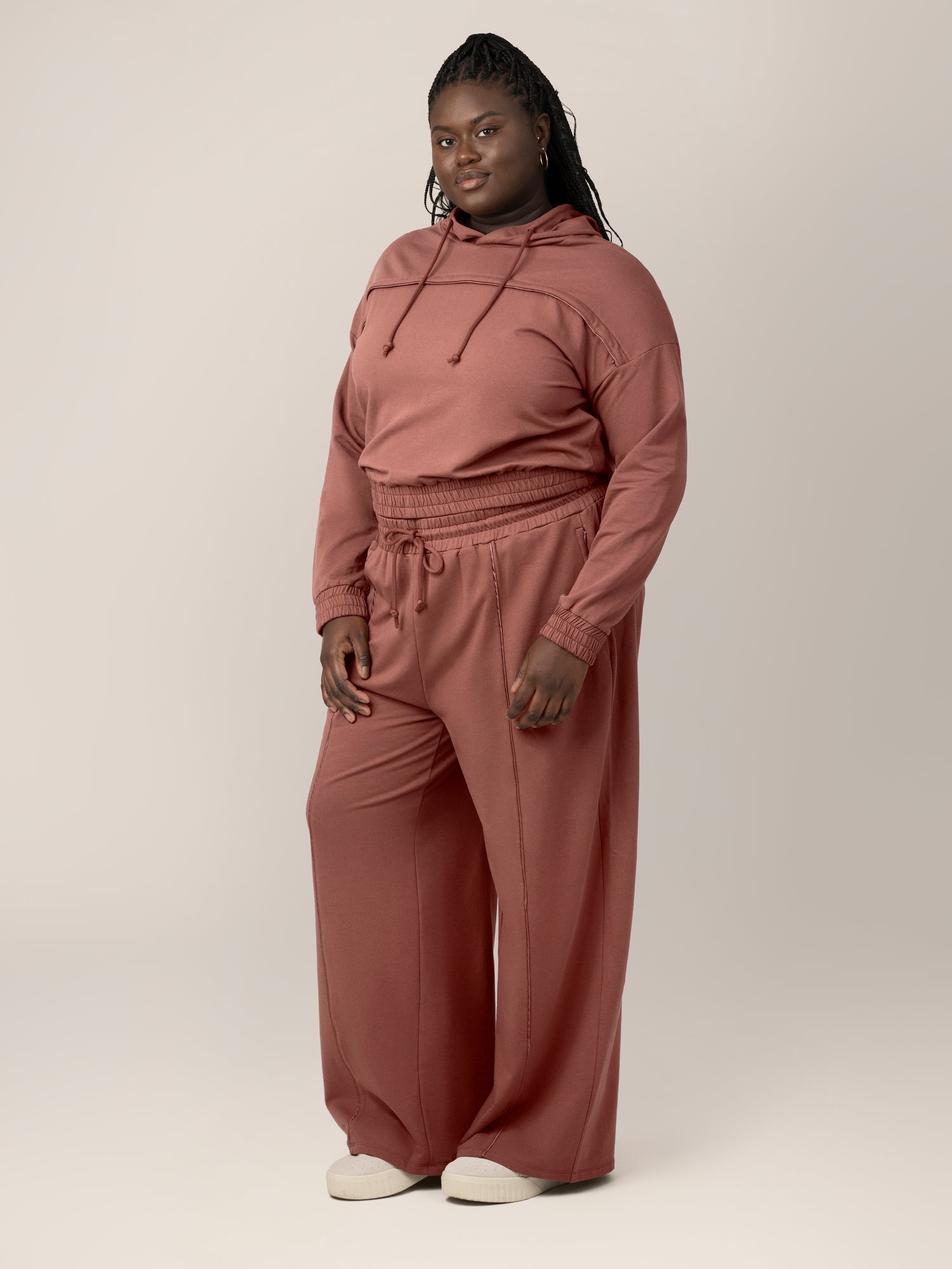 3/4 full body view of model wearing the Mila High-Waisted Wide Leg Pant in Redwood, paired with the matching Mila Cropped Nursing Hoodie in Redwood. 