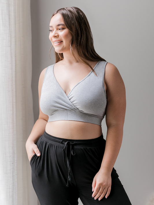 Model standing by window wearing the Organic Cotton Sleep & Nursing Bra in Grey Heather @model_info:Venezia is wearing an X-Large Busty.