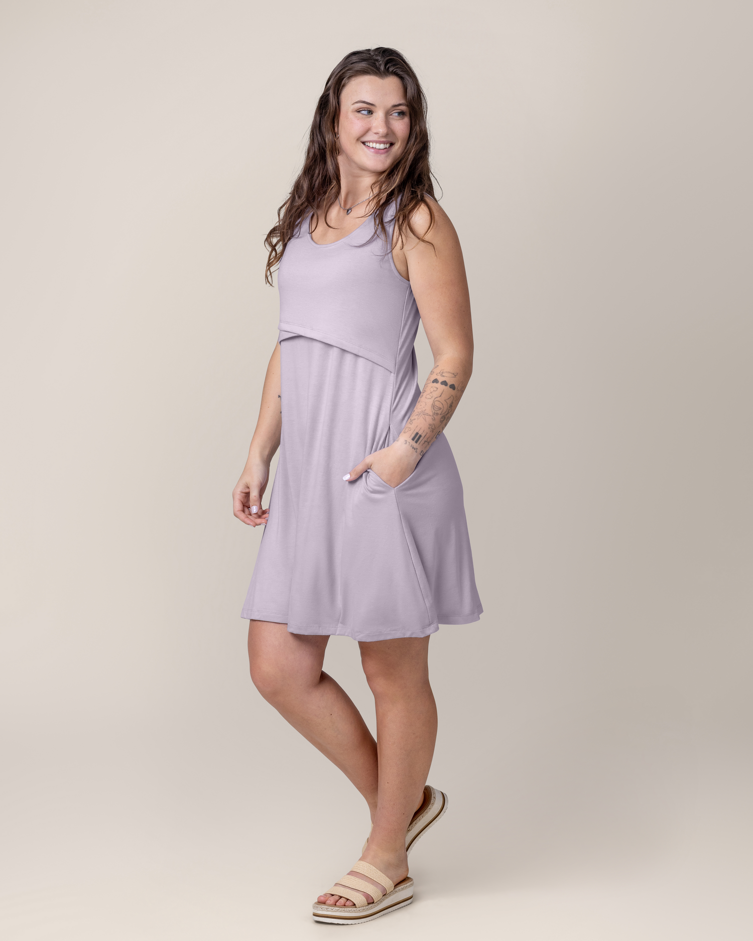 Side view of model wearing the Penelope Crossover Nursing Dress in Lavender Mist, with one hand in pocket