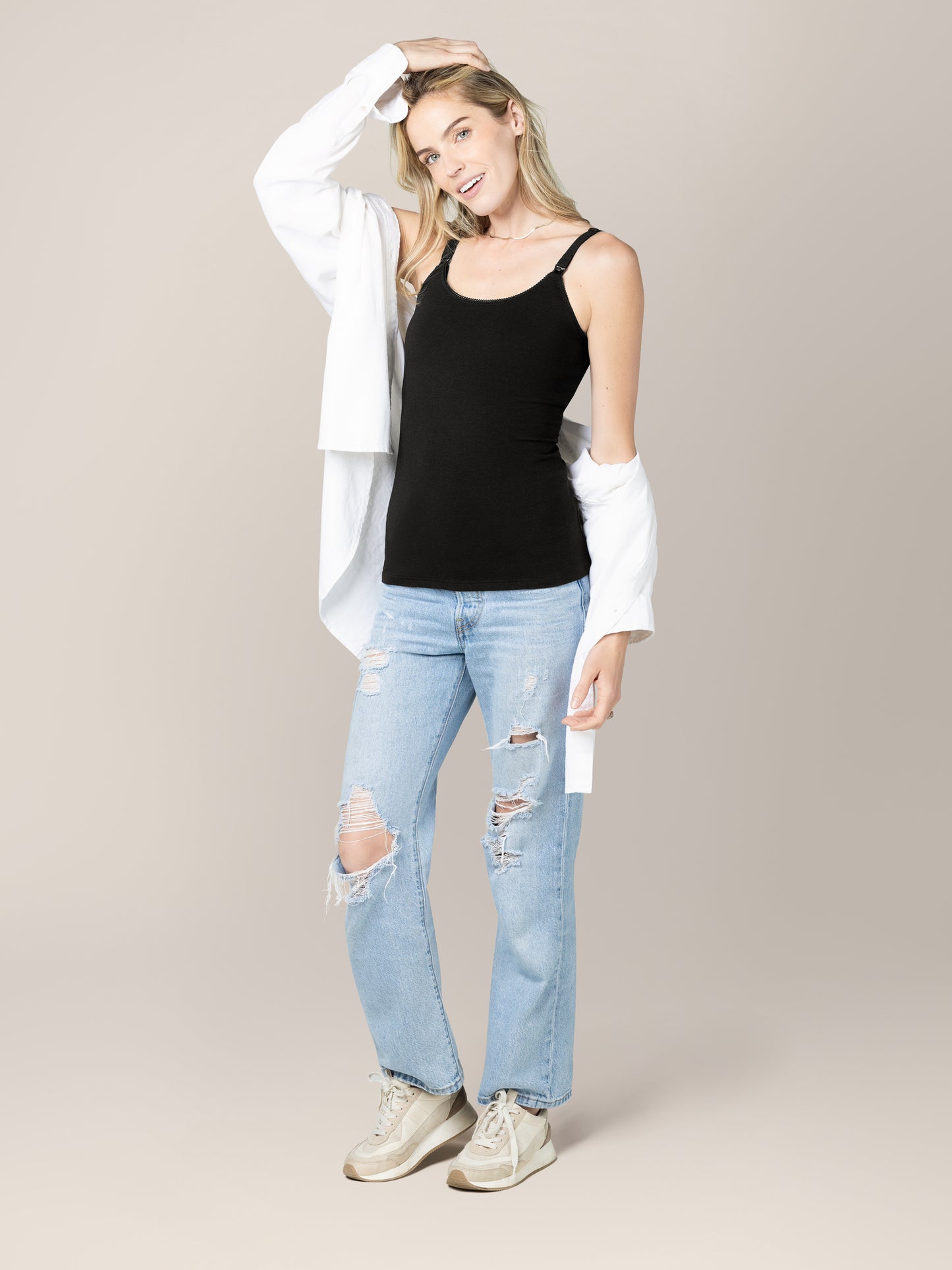 Front view of model wearing the Picot Trim Nursing Camisole in Black, paired with jeans, tennis shoes and an open button-down shirt. 