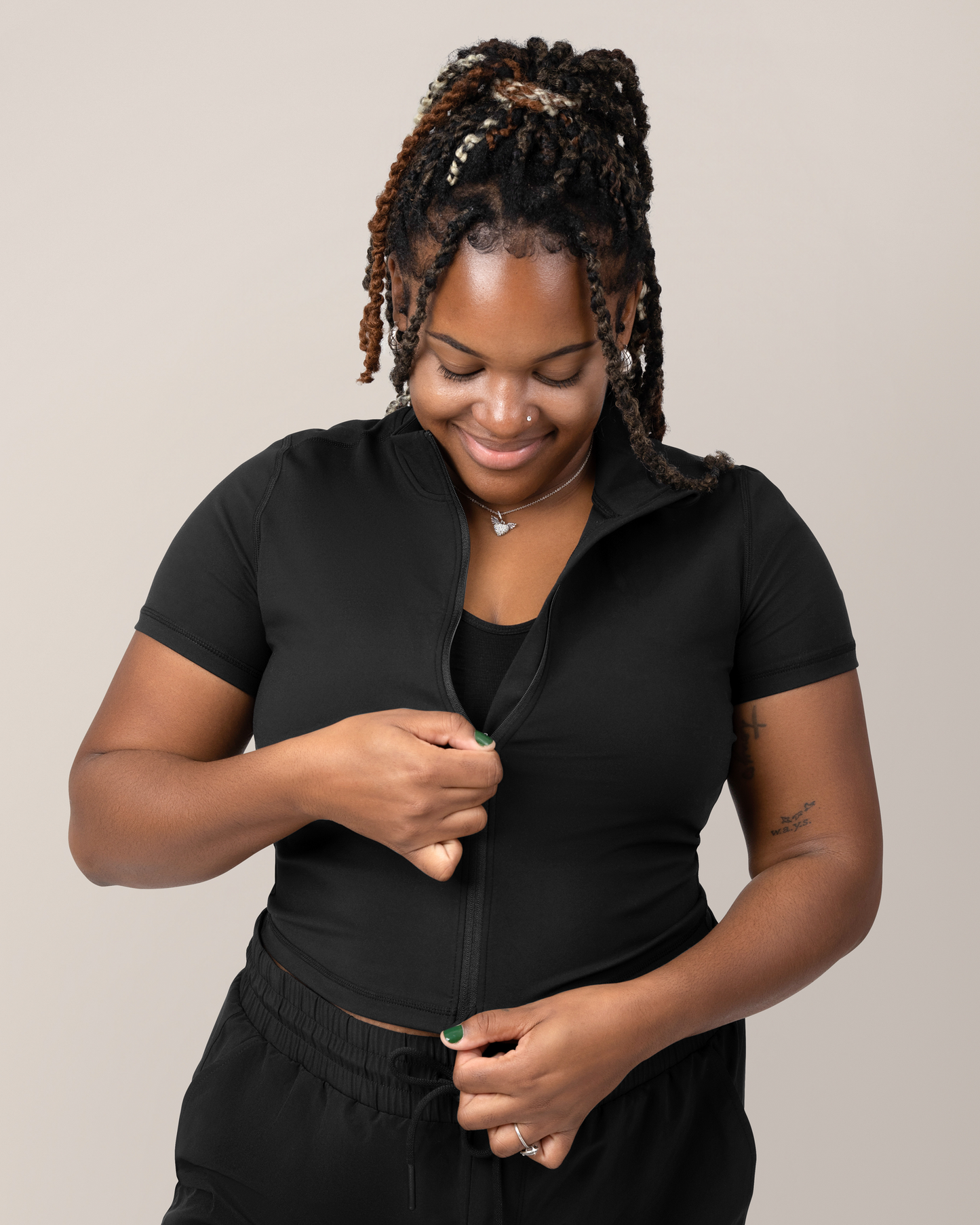 Front view of Model zipping up the Presley Active Zip Front Nursing Top in Black