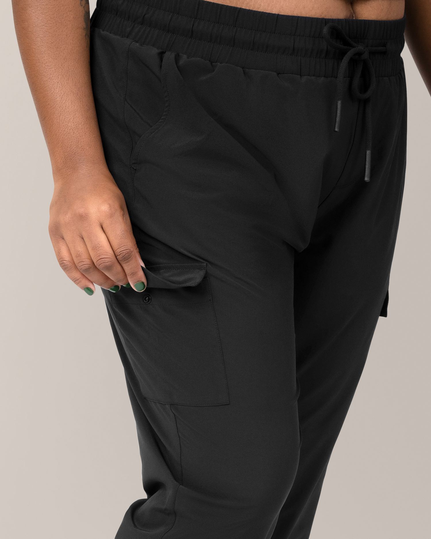 Close up of model wearing the Remy Maternity & Postpartum Cargo Jogger in Black, showing cargo pocket flap and snap detail