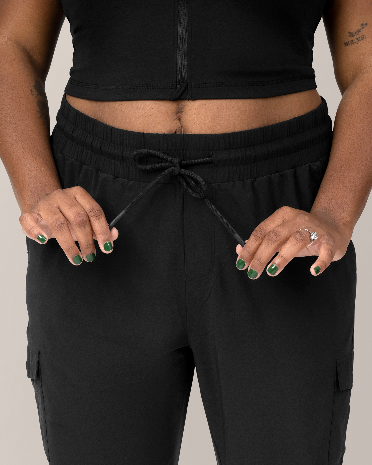 Close up of model wearing the Remy Maternity & Postpartum Cargo Jogger in Black, showing drawstring