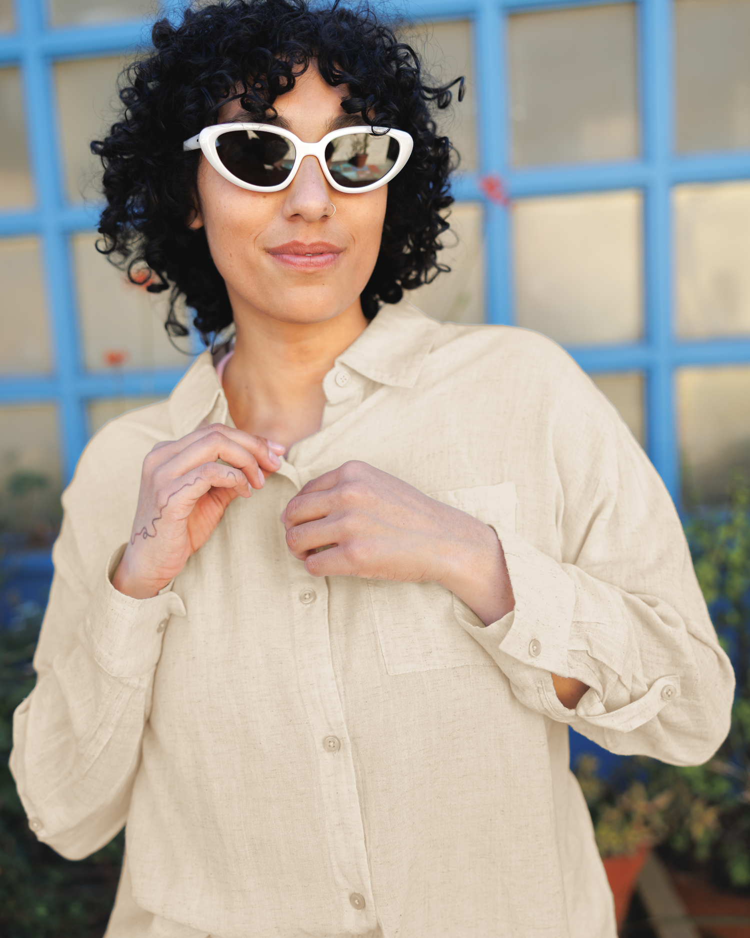 Close up of model wearing the Reese Oversized Linen Button Down Shirt in Natural, focusing on collar and buttons
@model_info:Indira is wearing a Large.