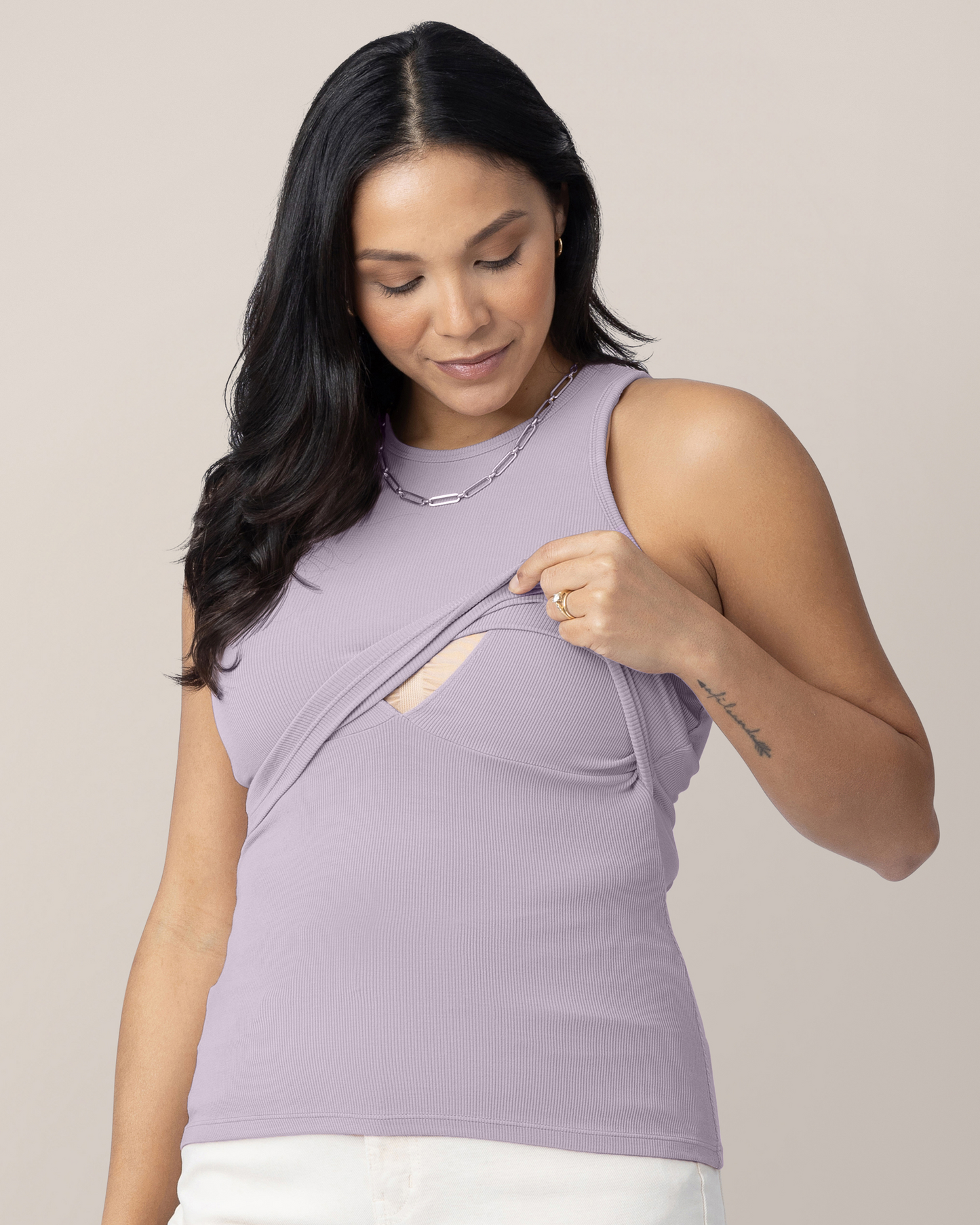 Model wearing the Ribbed Bamboo Racerback Nursing Tank in Lavender Mist, lifting outer layer to show nursing access