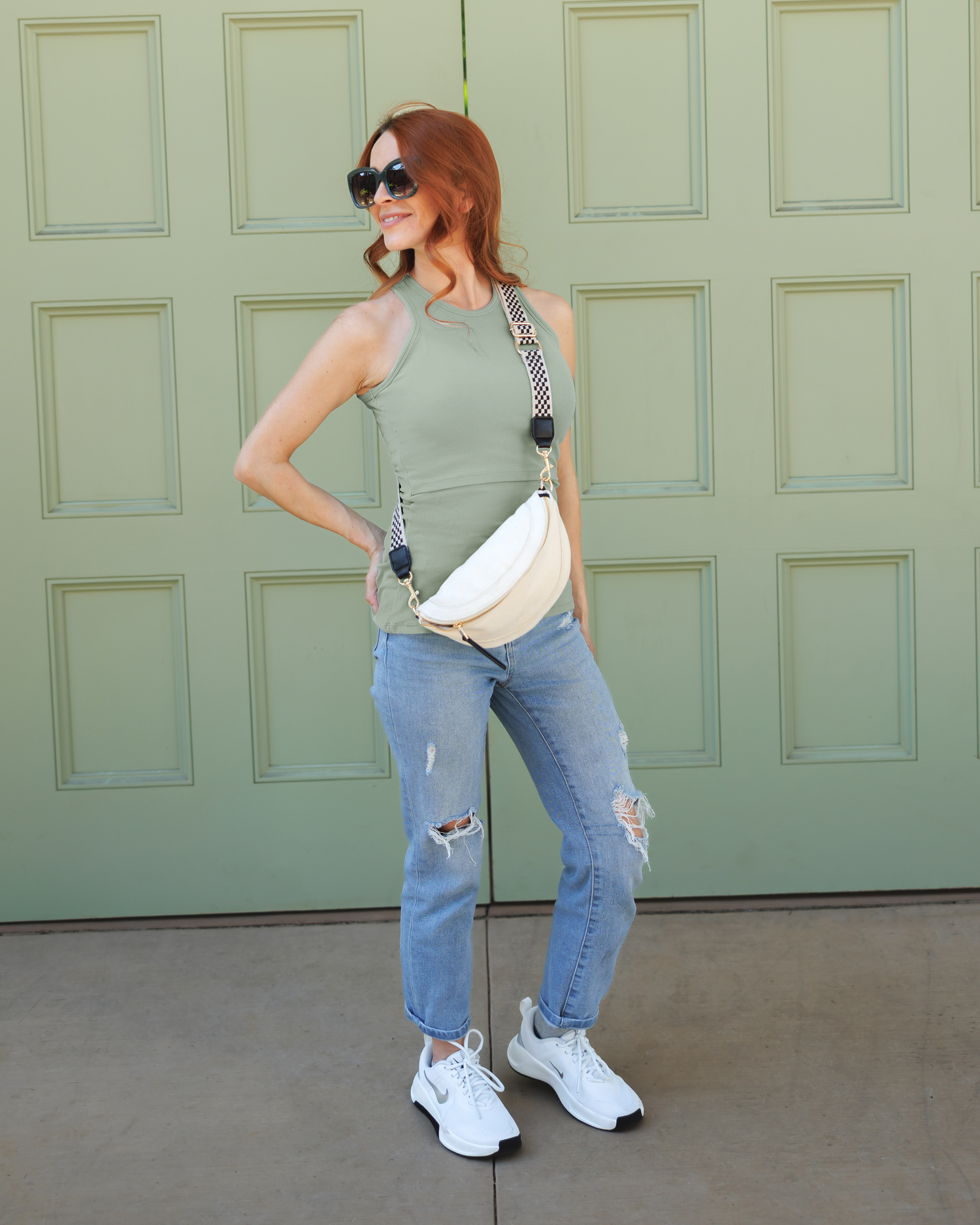 Model wearing the Ribbed Bamboo Racerback Nursing Tank 
 in Aqua Mist, paired with cropped jeans, tennis shoes and crossbody bag