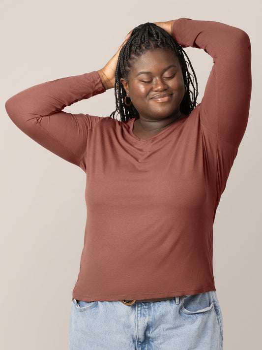 Front view of model wearing the Ribbed Bamboo Maternity & Nursing Long Sleeve T-shirt in Redwood, with hands on head @model_info:Bintou is wearing an X-Large.