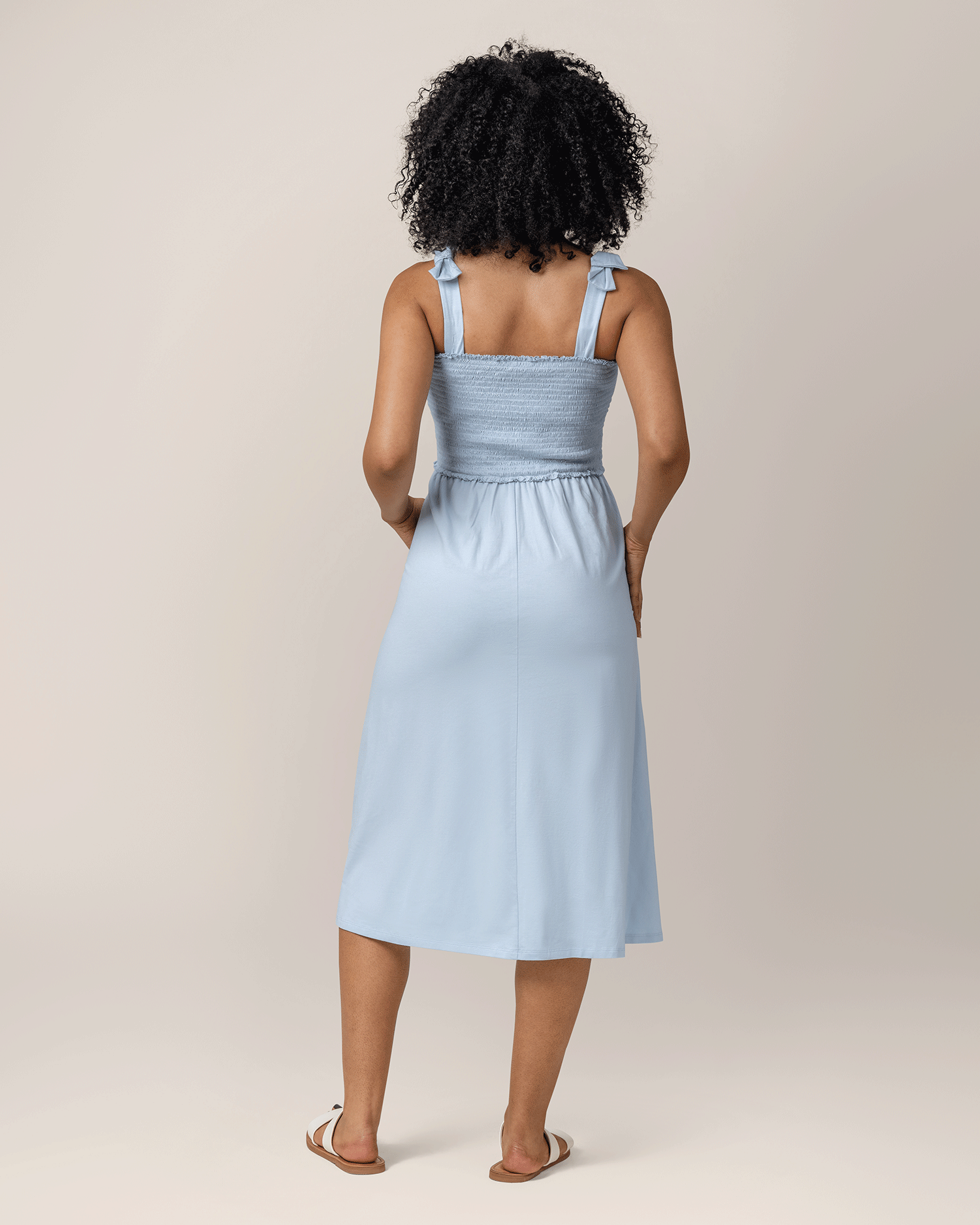 Back view of model wearing the Sienna Smocked Maternity & Nursing Dress in French Blue