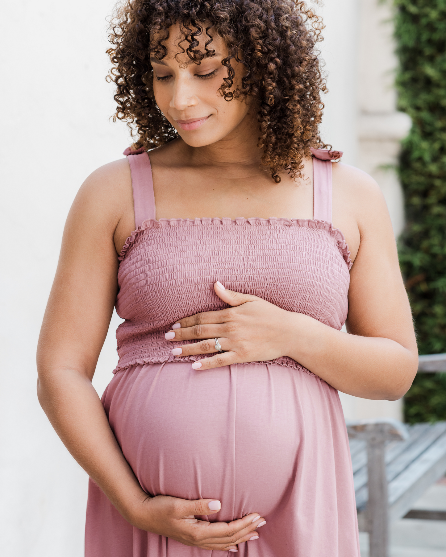 Close up of pregnant model outside wearing the Sienna Smocked Maternity & Nursing Dress in Light Mauve, showing smocked detail