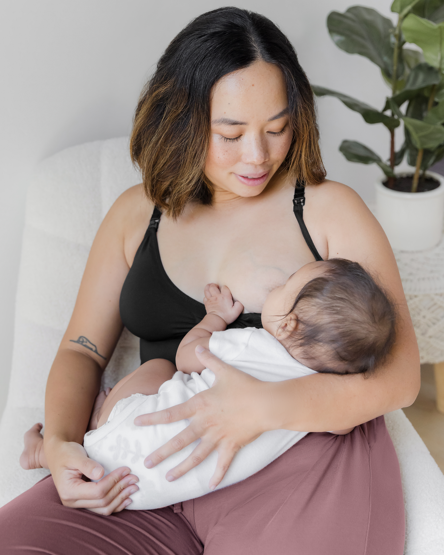 Model wearing the Simply Sublime Nursing Tank, nursing baby