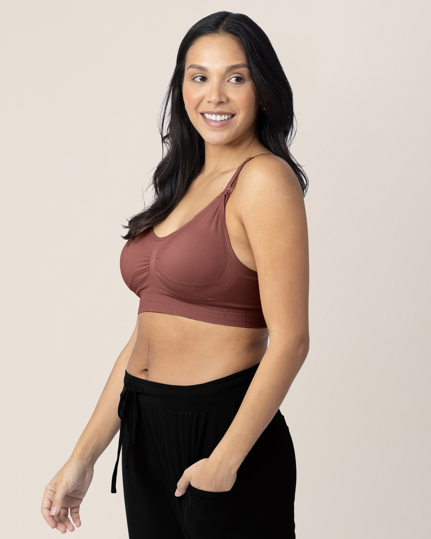 Side view of a model wearing the Simply Sublime® Nursing Bra in Redwood with her hand in her pocket.