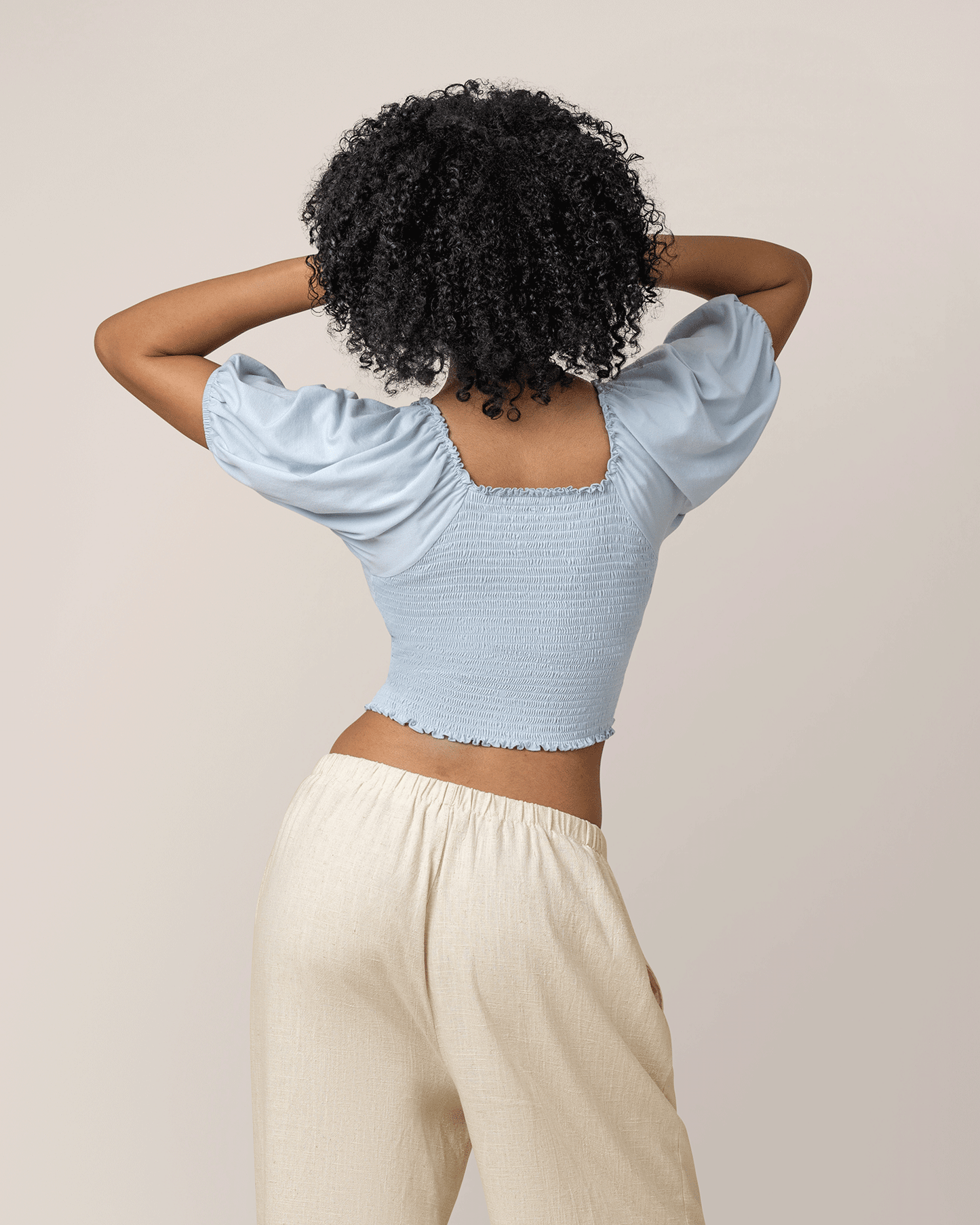 Back view of model wearing Sophia Smocked Cropped Nursing Top in French Blue 