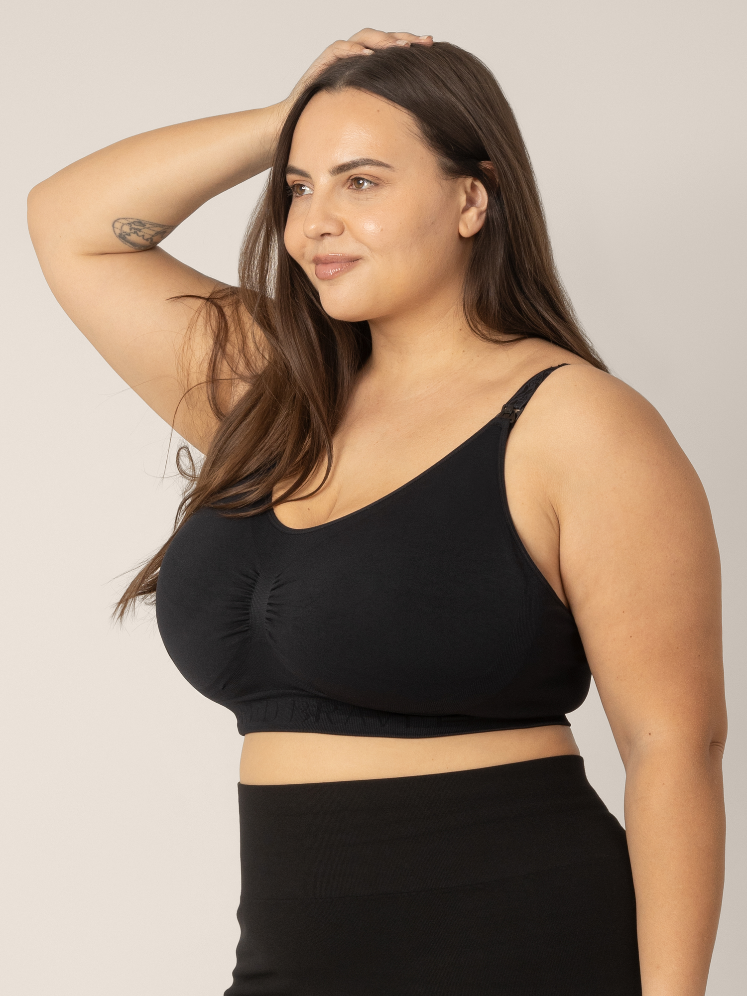 Side view of Super Busty model wearing the Sublime Hands-Free Pumping & Nursing Sleep and Lounge Bra in Black.