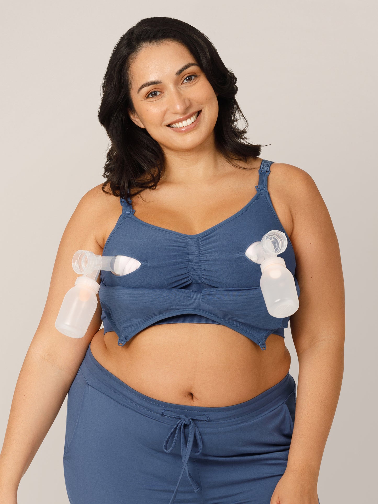 Front view of model wearing the Sublime® Hands-Free Pumping & Nursing Bra in Slate Blue in a Busty fit with pump flanges inserted.