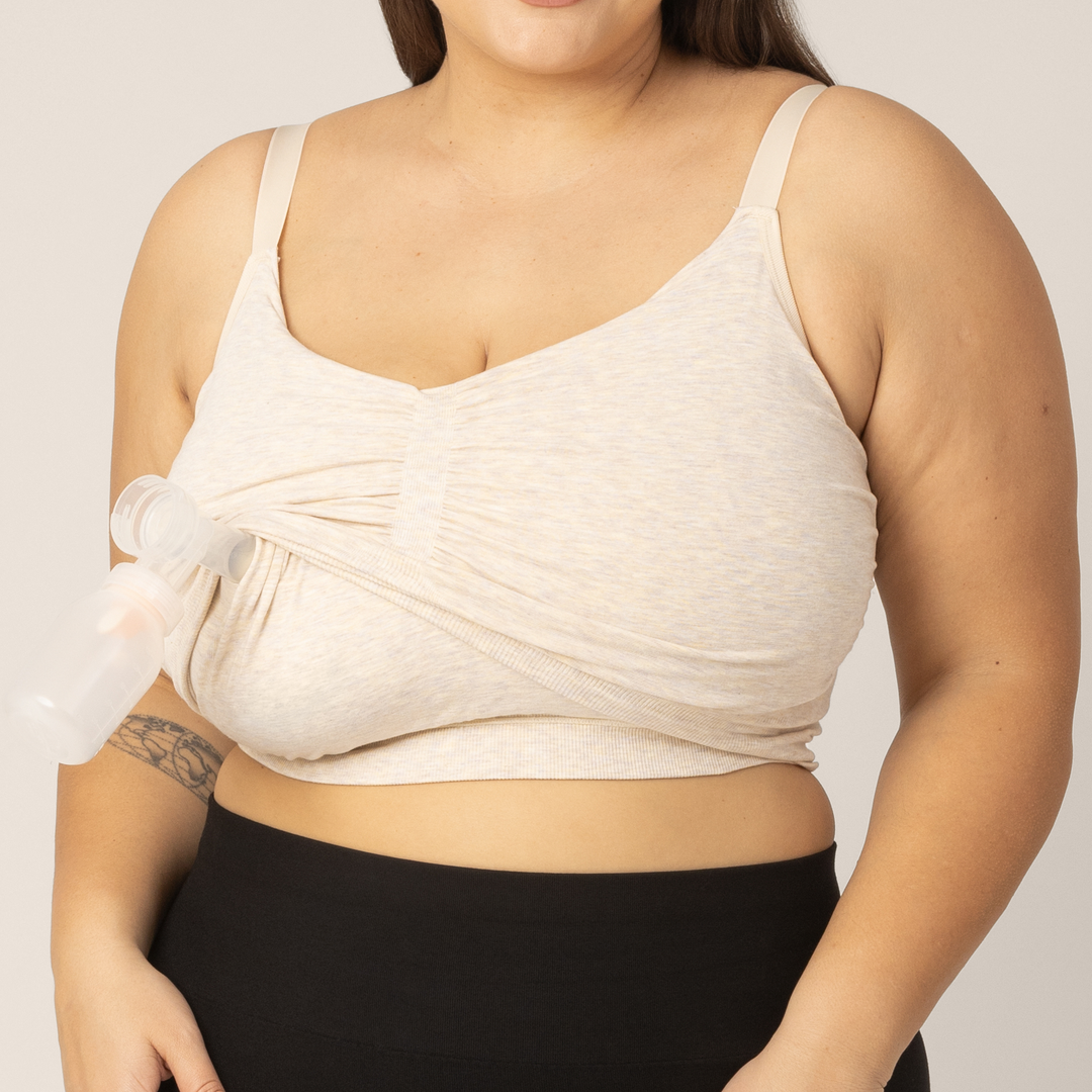 Side view of Super busty model wearing the Sublime Hands-Free Pumping & Nursing Sleep and Lounge Bra in Oatmeal Heather. Top layer pulled up to insert pumping for hands-free pumping access. 