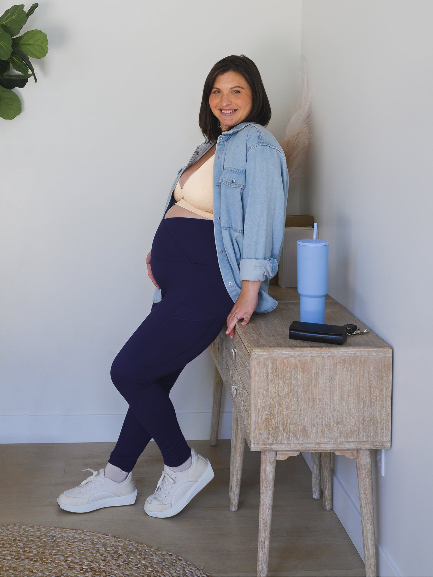 Model wearing the Sublime®️ Bamboo Maternity & Postpartum Crossover Legging in Navy, paired with the Sublime® Bamboo Maternity & Nursing Plunge Bra in Oatmeal Heather, and an open denim button down top