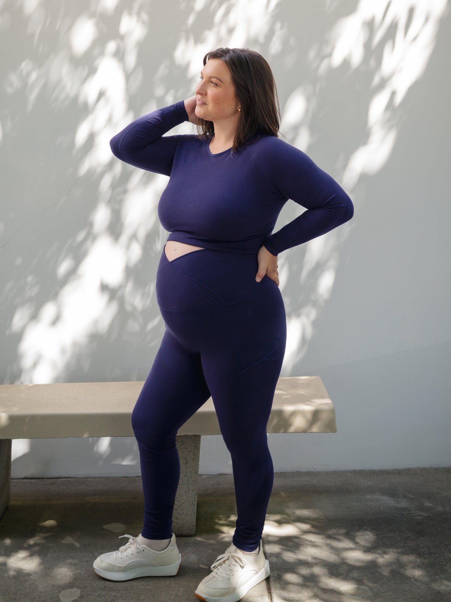 Model outside wearing the Sublime®️ Bamboo Maternity & Postpartum Crossover Legging in Navy, paired with matching Sublime® Bamboo Maternity & Nursing Cropped Long Sleeve Top. @model_info:Shelby is 5'6" and wearing a 1X.