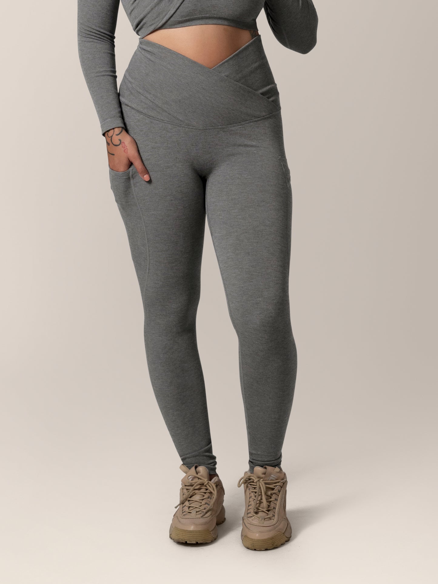 Front view of model wearing the Sublime®️ Bamboo Maternity & Postpartum Crossover Legging in Charcoal, with one hand in pocket