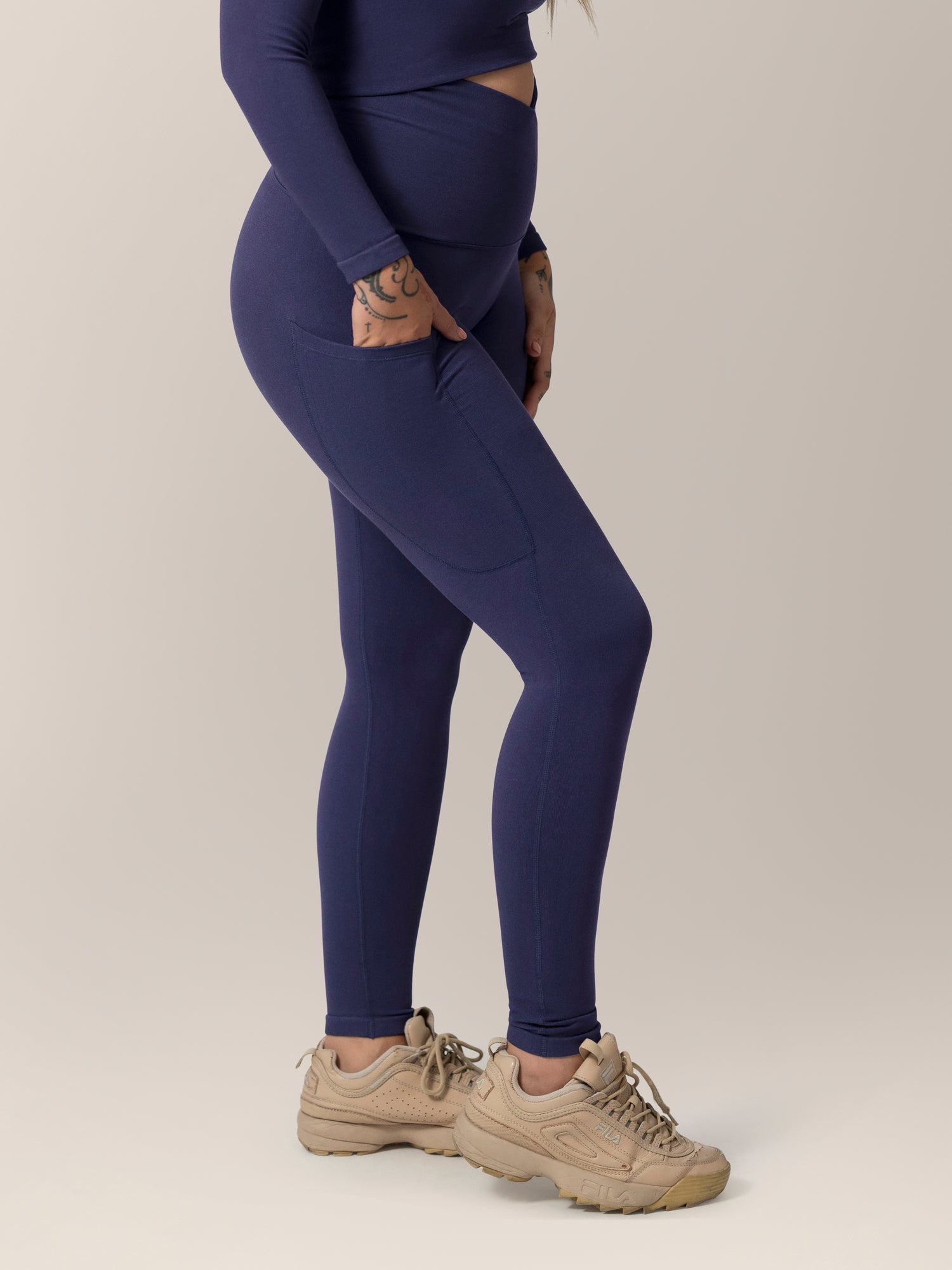 Side view of model wearing the Sublime®️ Bamboo Maternity & Postpartum Crossover Legging in Navy, with hand in pocket