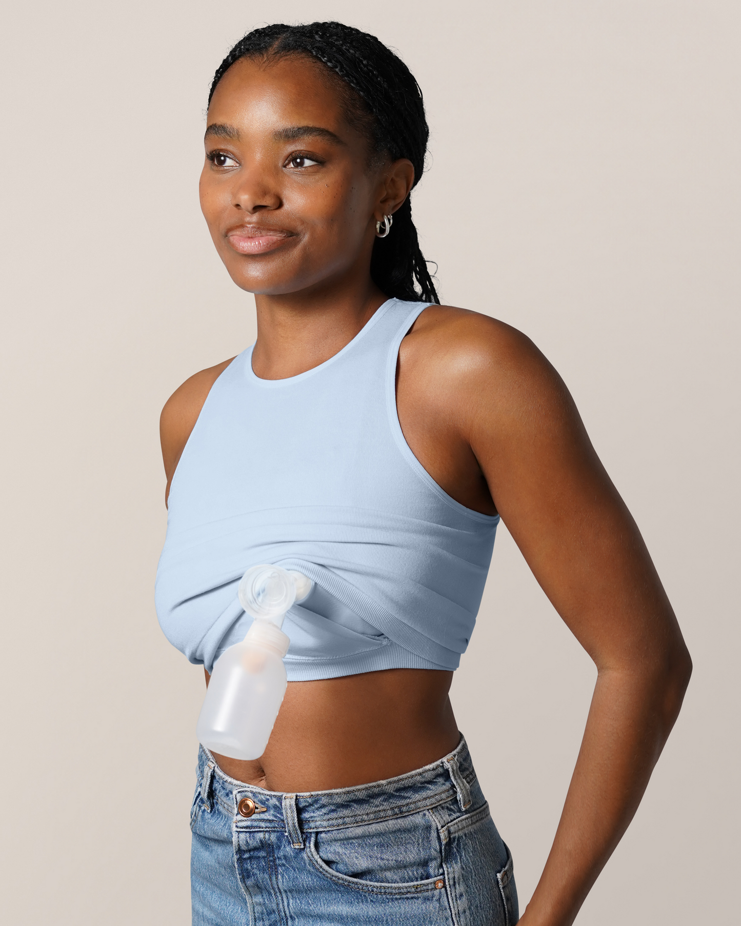 3/4 view of model wearing  the Sublime® Bamboo Hands-Free Pumping Longline Bra Top in French Blue, showing one pump flange with bottle inserted