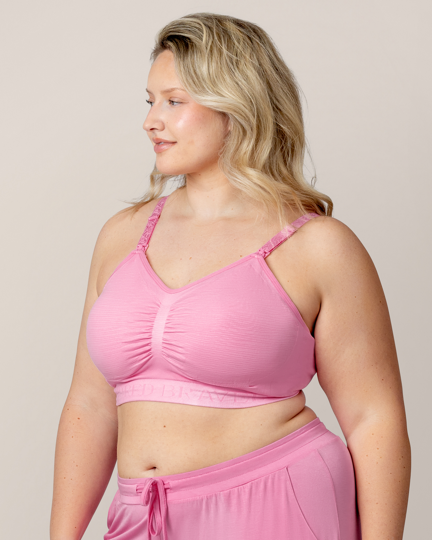 Side view of model wearing the Sublime® Hands-Free Pumping & Nursing Bra in Bubblegum with matching Everyday Lounge Joggers @model_info:Austen is wearing an X-Large Busty.