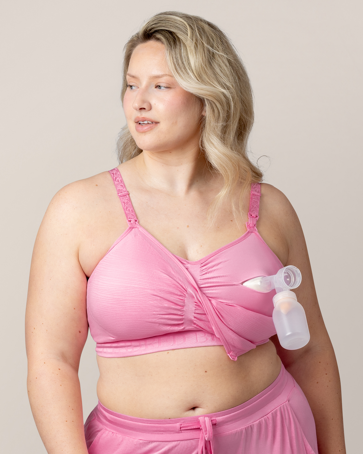 Side view of model pumping while wearing the Sublime® Hands-Free Pumping & Nursing Bra in Bubblegum with matching Everyday Lounge Joggers 