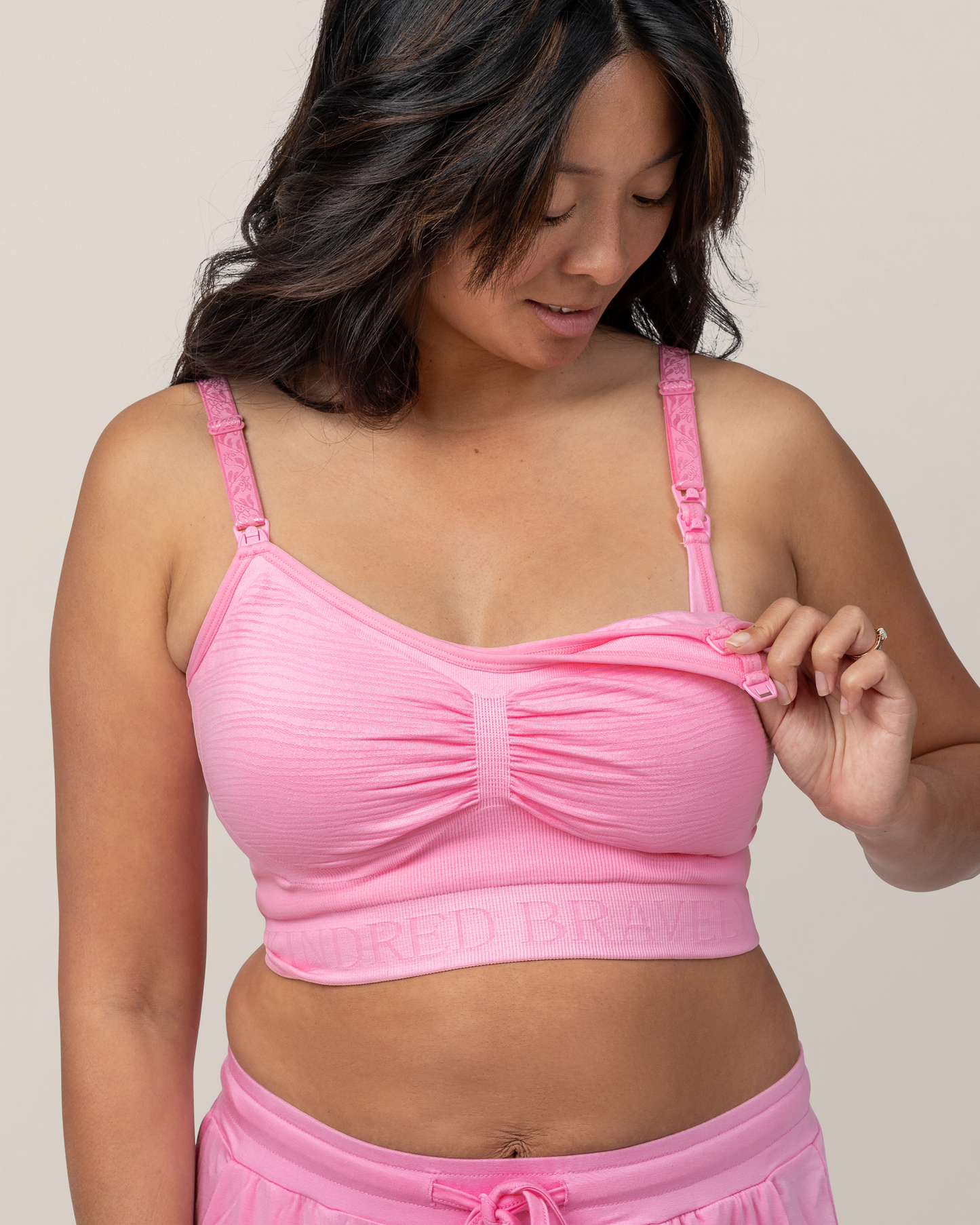 Model showing clip down nursing and pumping access while wearing Sublime® Hands-Free Pumping & Nursing Bra in Bubblegum with matching Everyday Lounge Joggers