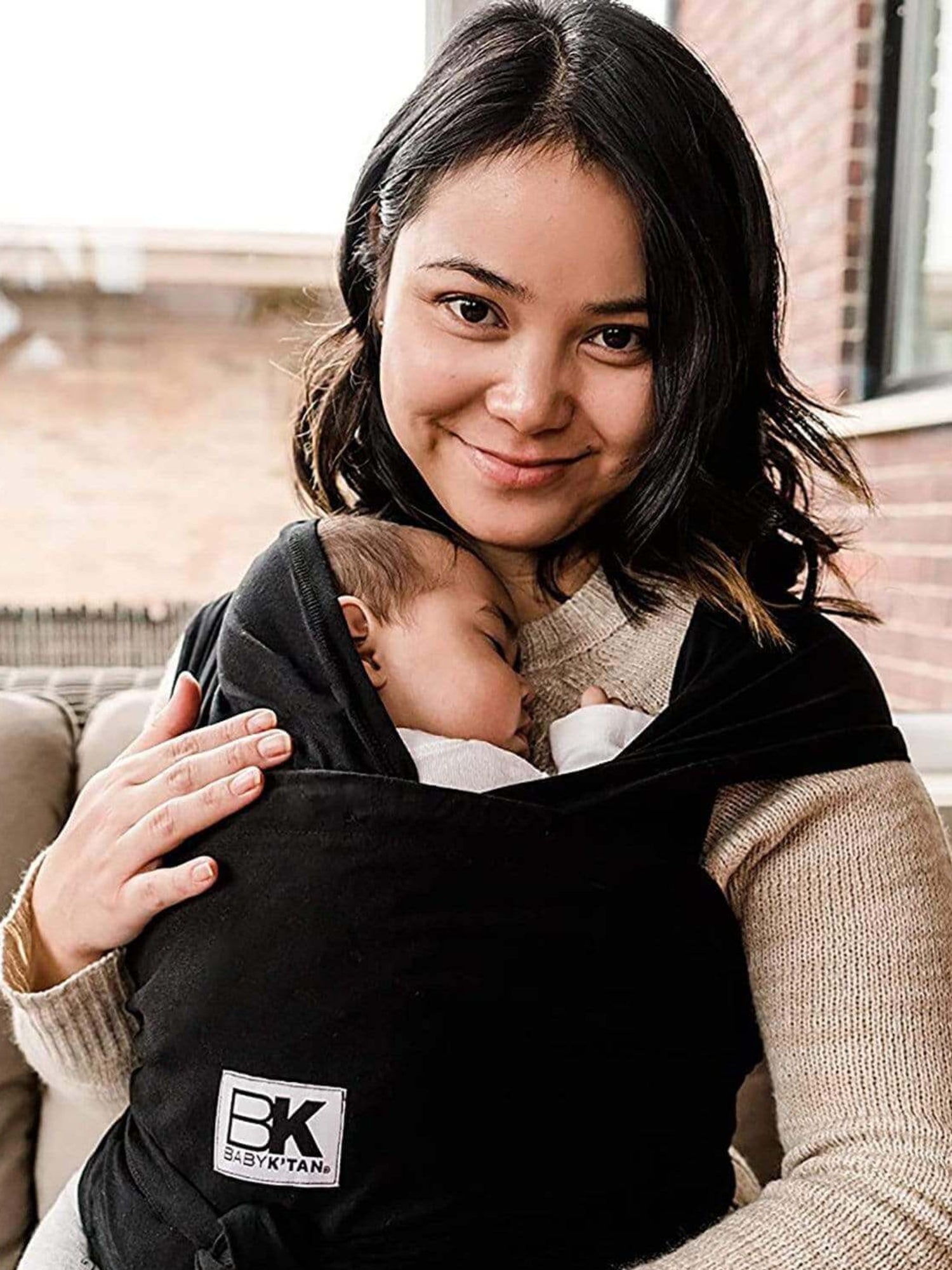 Model wearing baby in the Baby K'tan Original Baby Carrier in Black