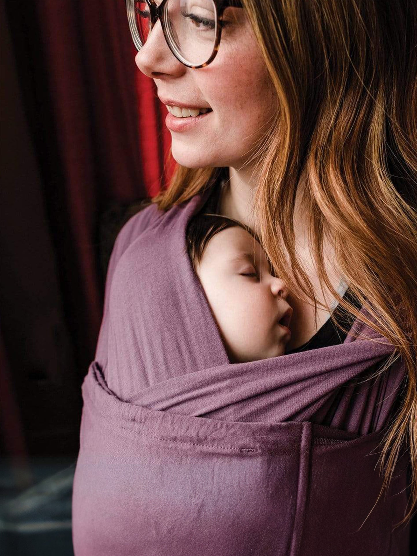 Model wearing baby in the Baby K'tan Original Baby Carrier in Eggplant